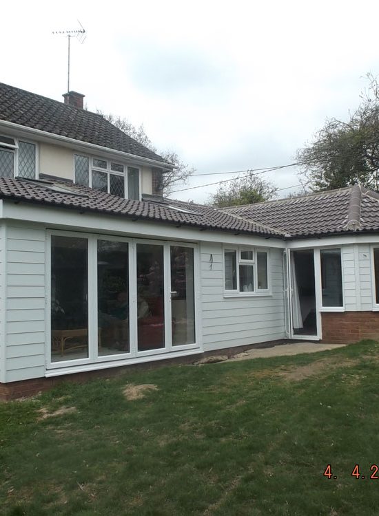 Rear single storey extension finished with weatherboarding and pan tiled roof.