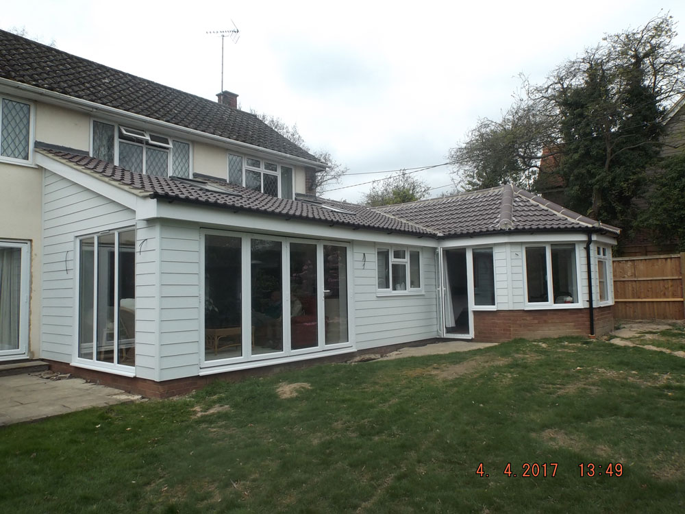 Rear single storey extension finished with weatherboarding and pan tiled roof.