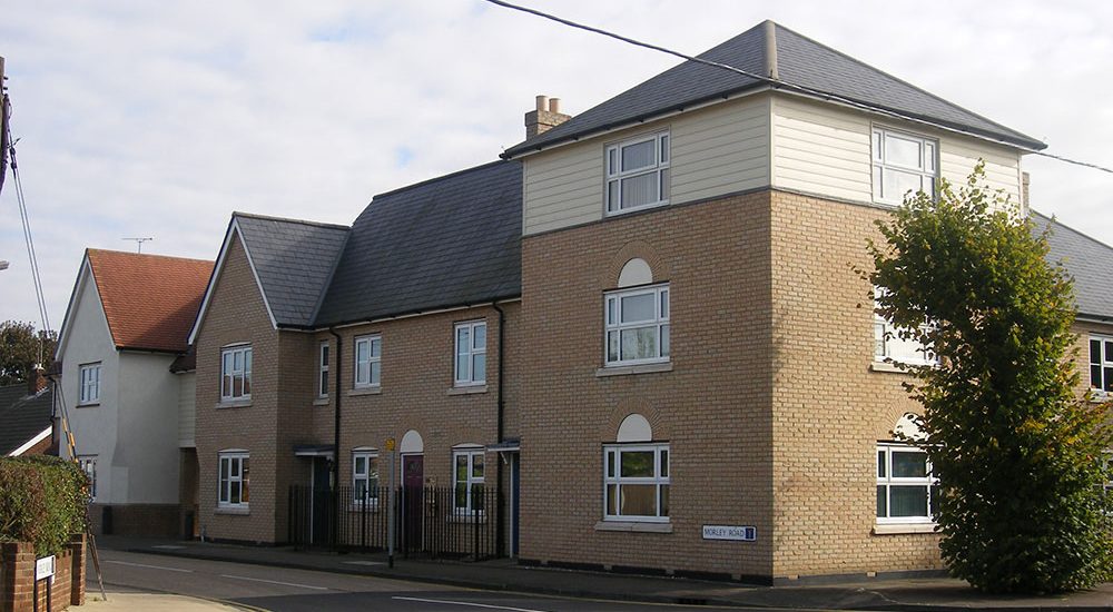 Three storey element accommodating offices with a mix of apartments and housing either side.