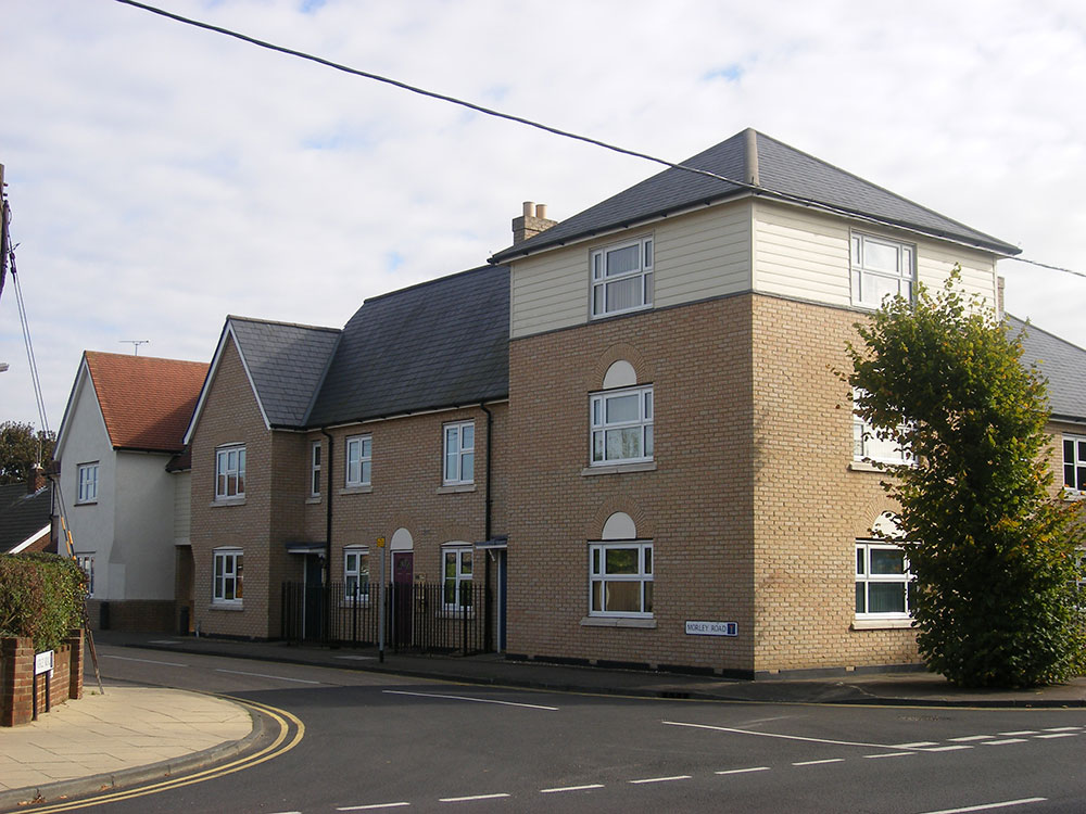 Three storey element accommodating offices with a mix of apartments and housing either side.